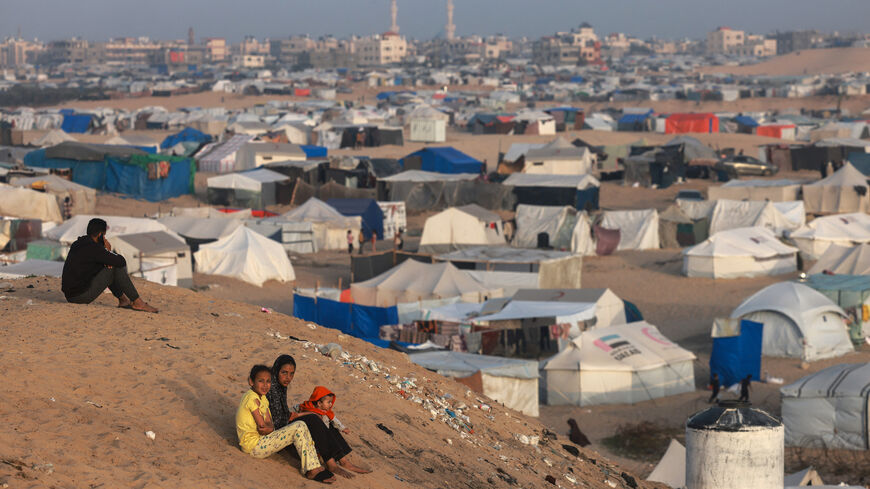Palestinian children sit on a hill next to tents housing the displaced in Rafah in the southern Gaza Strip on March 30, 2024 amid the ongoing conflict in the Palestinian territory between Israel and the militant group Hamas.