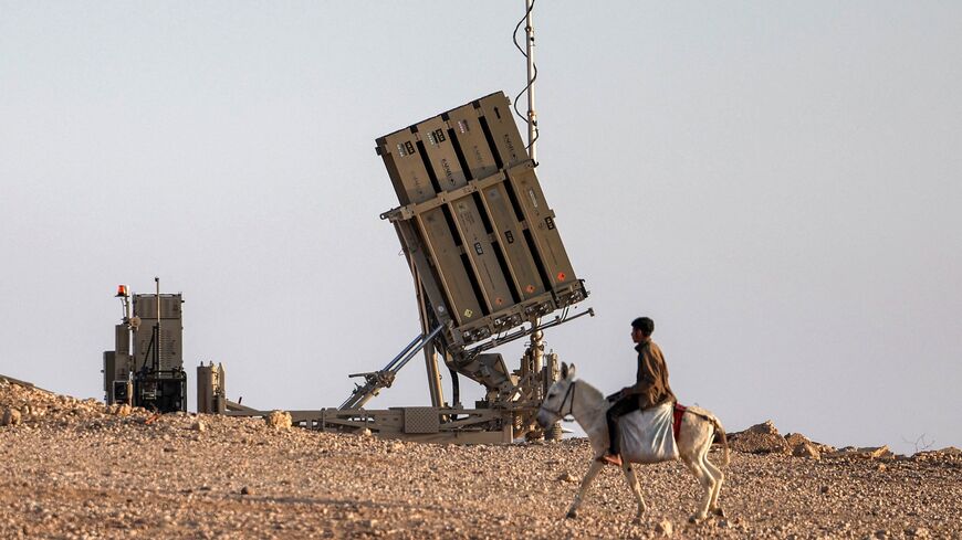 A boy rides a donkey near one of the batteries of Israel's Iron Dome missile defense.