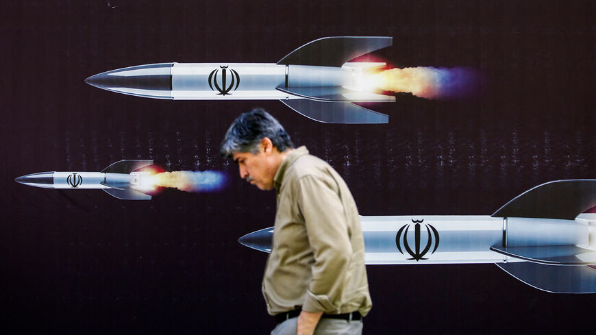 A man walks past a banner depicting missiles along a street in Tehran on April 19, 2024. Iran's state media reported explosions in the central province of Isfahan on April 19, as US media quoted officials saying Israel had carried out retaliatory strikes on its arch-rival. (Photo by AFP) (Photo by -/AFP via Getty Images)