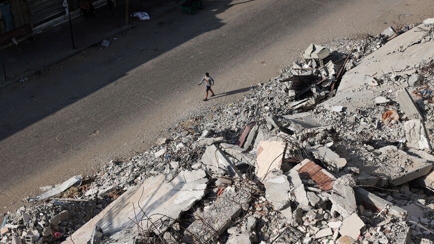 A Palestinian man walks past the rubble of buildings destroyed in Israeli bombardments, in Rafah, in the southern Gaza Strip, on April 30, 2024 