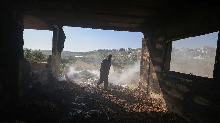 A Palestinian inspects the damage to a home in the village of Al-Mughayyir near Ramallah in theoccupied West Bank, after an attack by Israeli settlers