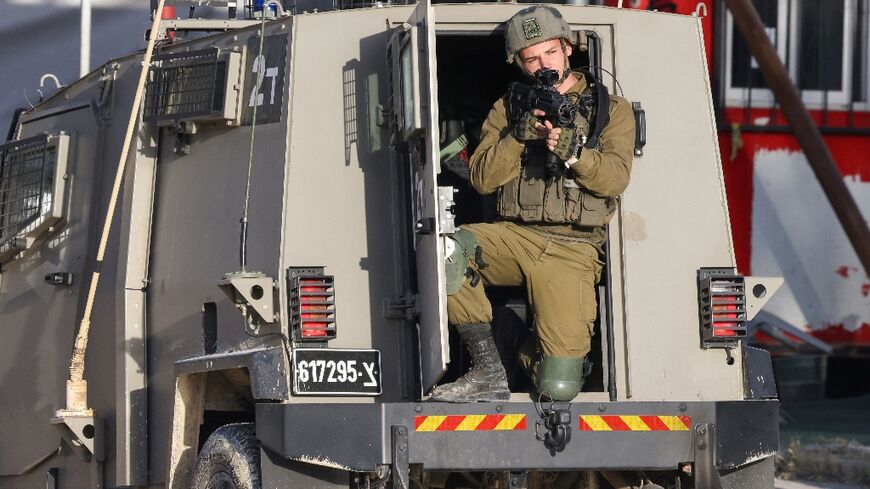 An Israeli soldier aims his rifle during a raid on the Nur Shams refugee camp in the occupied West Bank