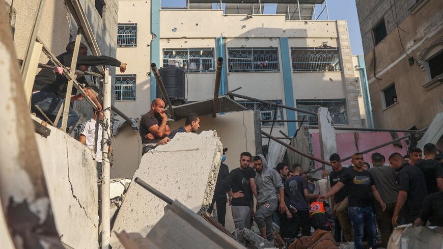 Palestinians search for casualties in the rubble of a house destroyed in an Israeli strike on Rafah, in the southern Gaza Strip
