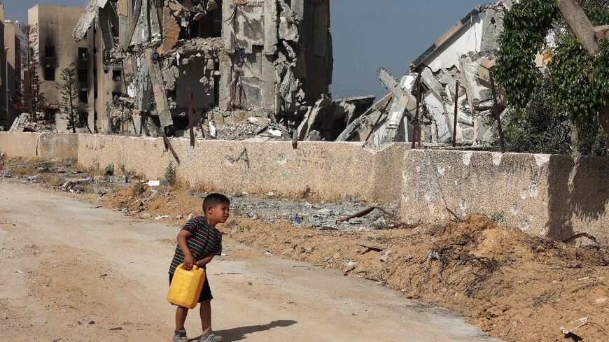 A Palestinian boy carries a water canister in Beit Lahya in the northern Gaza Strip, where the World Food Programme has warned of a "full-blown famine"
