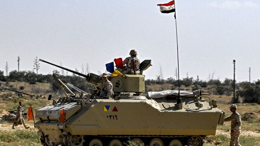 Egyptian army soldiers man an infantry fighting vehicle deployed near the Egyptian side of the Rafah border crossing