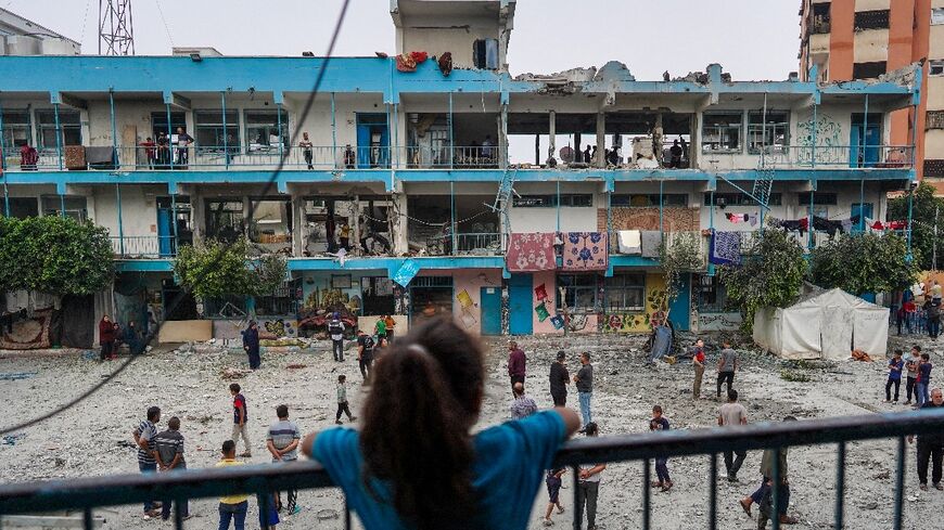 A girl watches as others check a UN-school housing displaced people that was hit during Israeli bombardment in Nuseirat on June 6, 2024