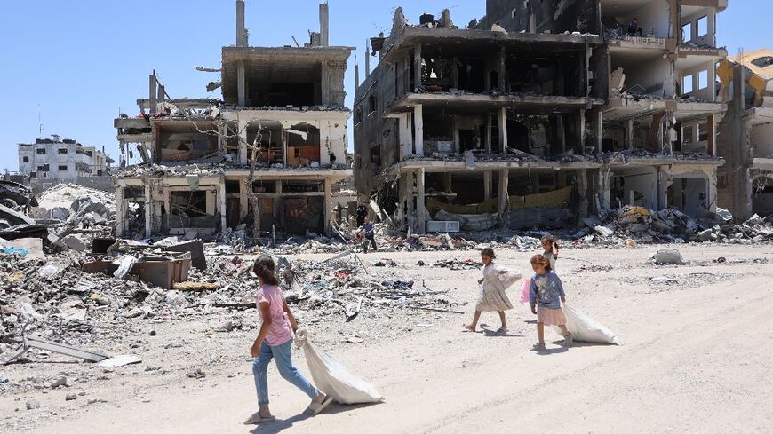 Palestinian children walk past destroyed buildings in the Jabalia refugee camp in northern Gaza 