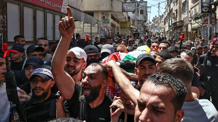 Pallbearers carry the body of Palestinian militant Wael Masha through the streets of Balata refugee camp in the occupied West Bank after he was killed in an Israeli air strike on August 15, less than a year after he was released in a prisoner swap