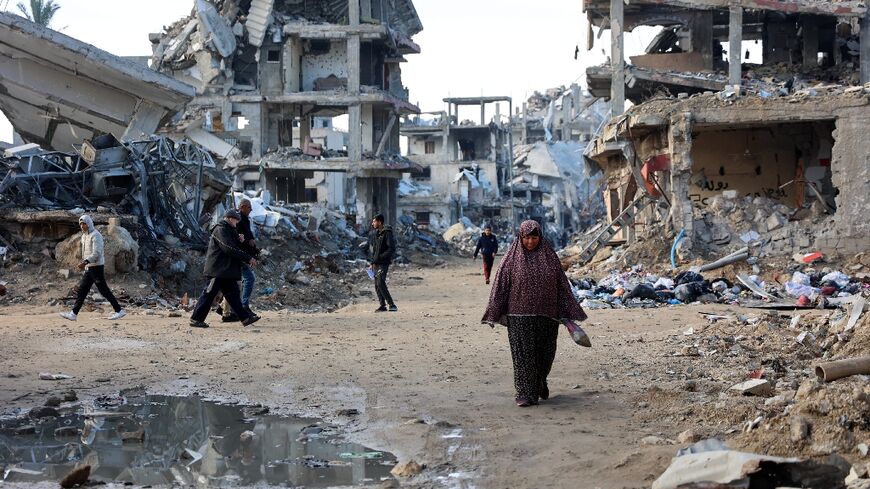 Palestinians walk amid the destruction in the Shujaiya neighbourhood of Gaza City