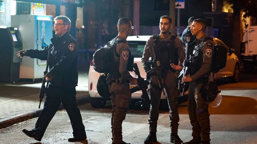 Israeli security forces stand guard at the scene of a Tel Aviv stabbing which wounded one person on the eve of the start of a Gaza truce.