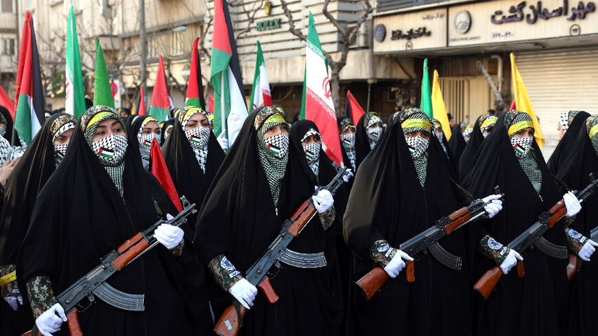Members of Iranian paramilitary Bassij women's forces march with weapons during the rally in Tehran