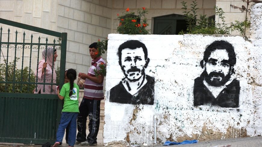 Graffiti of Nael Barghouti (L) and another long-serving Israeli prisoner Fakhri Barghouti, in the occupied West Bank village of Kubar on October 16, 2011