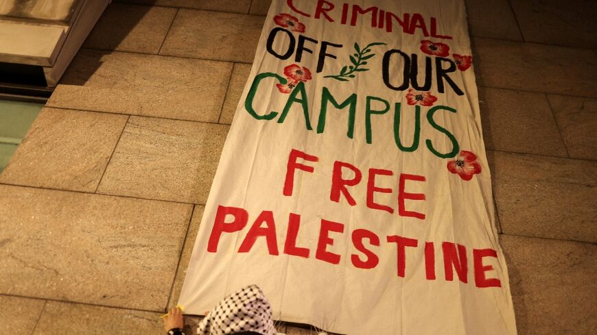 Pro-Palestinian protesters hang a banner as they gathered outside the campus of Columbia University in New York City 