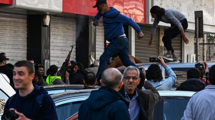 A gunman fires shots in the air to disperse clashing protesters in Syria's capital Damascus, after reported mass killings of the minority Alawite community