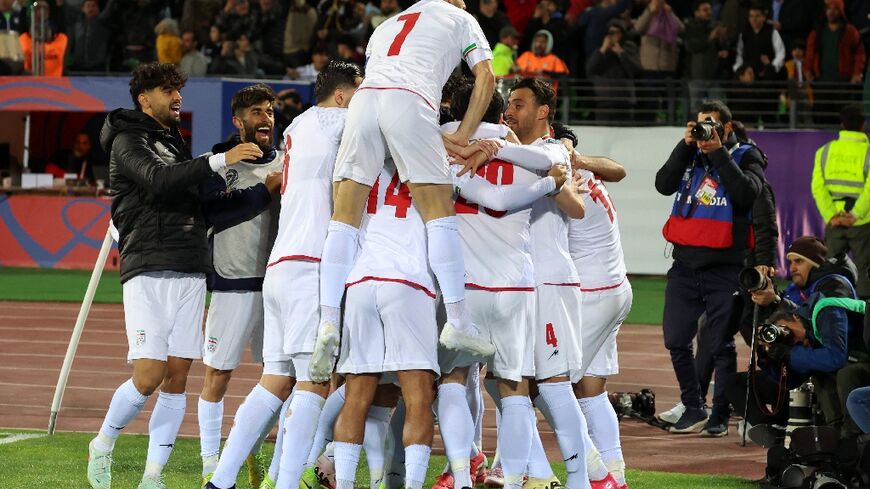 Iran's players celebrate after securing their place in the World Cup