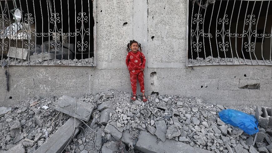 A crying Palestinian girl stands over the debris of a house hit by an Israeli strike in the south Gaza city of Khan Yunis on Wednesday.