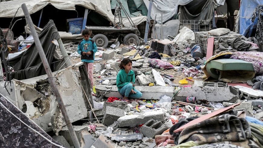 A young girl sat in the midst of a sea of rubble and metal rods after an Israeli strike in Deir el-Balah