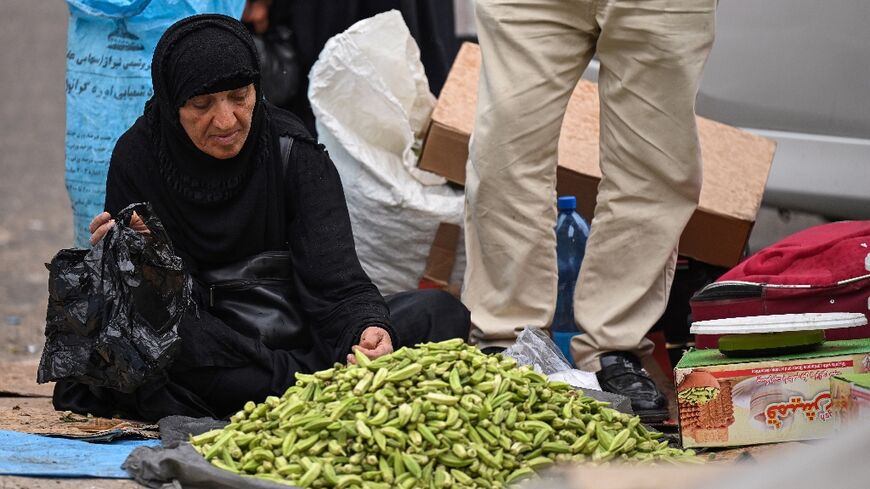 An Iranian woman sells okra at the old market in Iraq's southern city of Basra