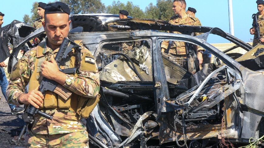 Lebanese soldiers at the site near a burnt-out vehicle in Ghaziyeh, near Sidon -- the health ministry said an Israeli strike killed one person