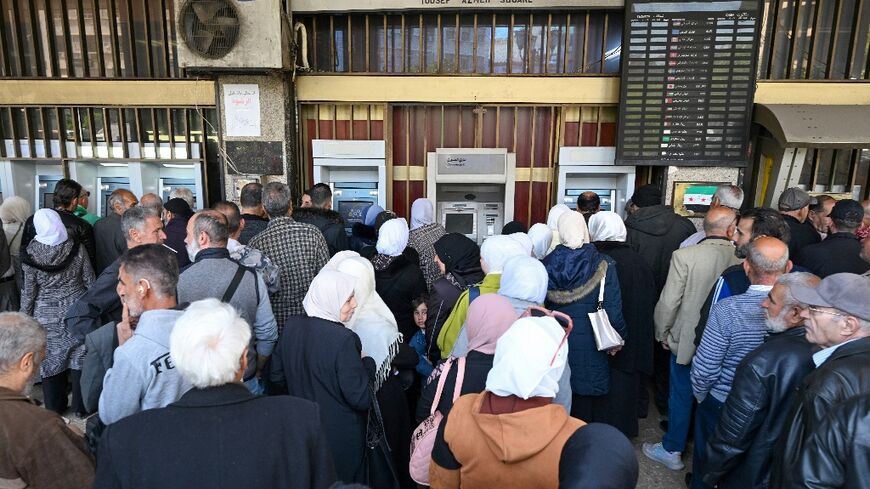 Syrian civil servants must queue at one of two state banks or affiliated ATMs, and withdrawals are capped