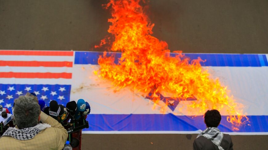 Demonstrators burn US and Israeli flags during a Sanaa rally in solidarity with Palestinians in the Gaza Strip