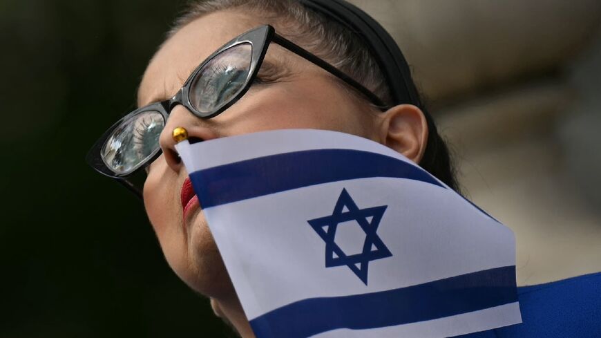 A woman holds an Israeli flag in a sign of support outside the Capital Jewish Museum following a shooting that left two people dead