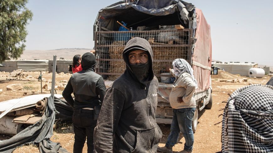 Men load a truck with their belongings in Maghayer al-Deir, east of Ramallah in the occupied West Bank