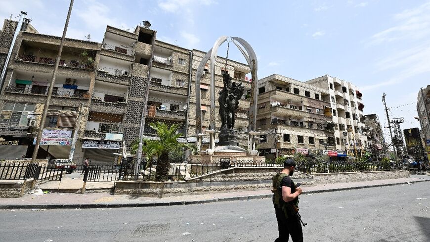 An armed man walks through the mostly Druze and Christian Damascus suburb of Jaramana, which came under attack by Islamists this week
