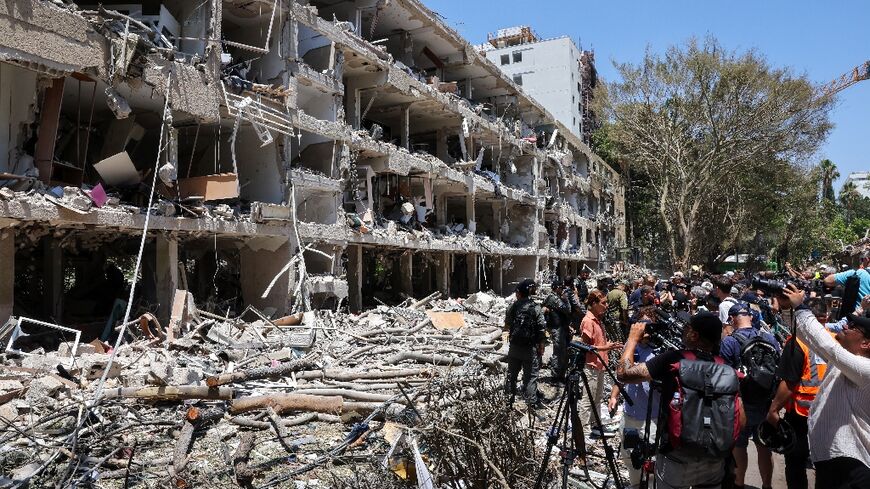 Israeli security forces and media gather at the site of an Iranian strike that hit a residential neighbourhood in the Ramat Aviv area in Tel Aviv on June 22, 2025