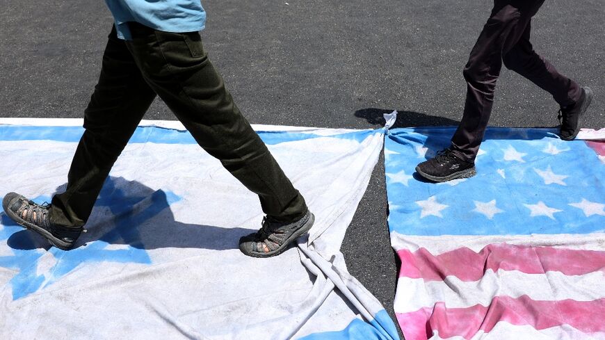 Iranians step on Israeli and American flags during a rally in Tehran