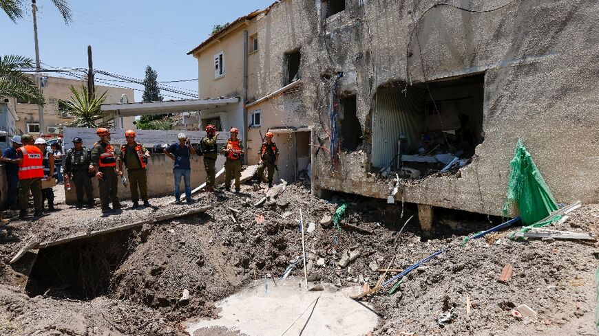 Israeli soldiers and first responders check the damage caused to a building in Beit She'an 