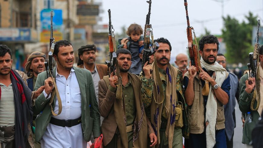 Yemenis brandish their rifles as they chant anti-Israel and anti-US slogans during a rally in the Huthi-run capital Sanaa