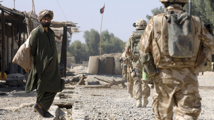 FILE PHOTO: British Army soldiers patrol through a market street in southern Helmand province, Afghanistan, November 7, 2007. REUTERS/Steve Lewis/File Photo