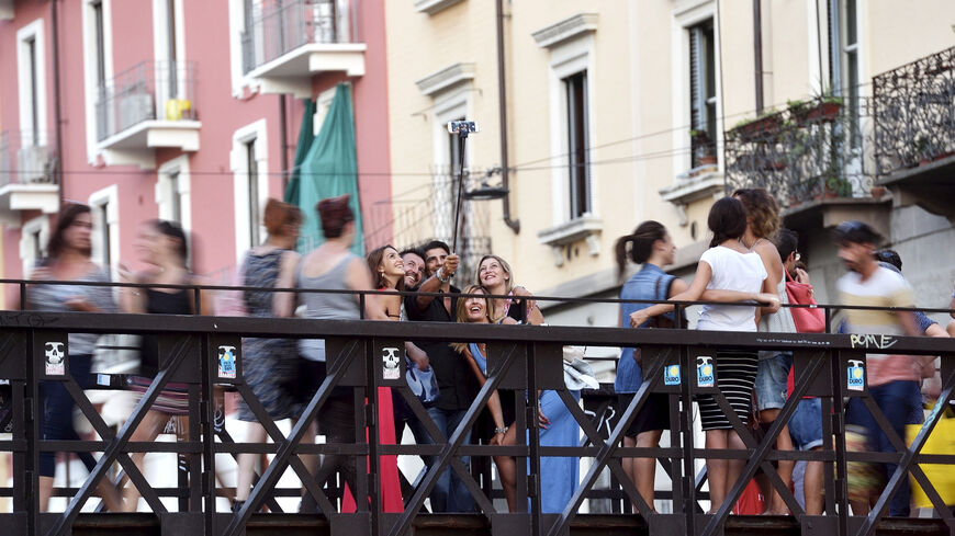 FILE PHOTO: People take a selfie at Naviglio Gran Canal in Milan, August 29, 2015. REUTERS/Flavio Lo Scalzo/File Photo