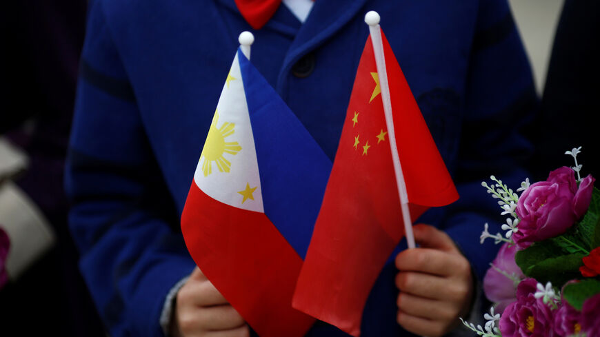 FILE PHOTO: Children hold plastic flowers, national flags of China and the Philippines before President of the Philippines Rodrigo Duterte and China's President Xi Jinping attend a welcoming ceremony at the Great Hall of the People in Beijing, China, October 20, 2016. REUTERS/Thomas Peter/File Photo