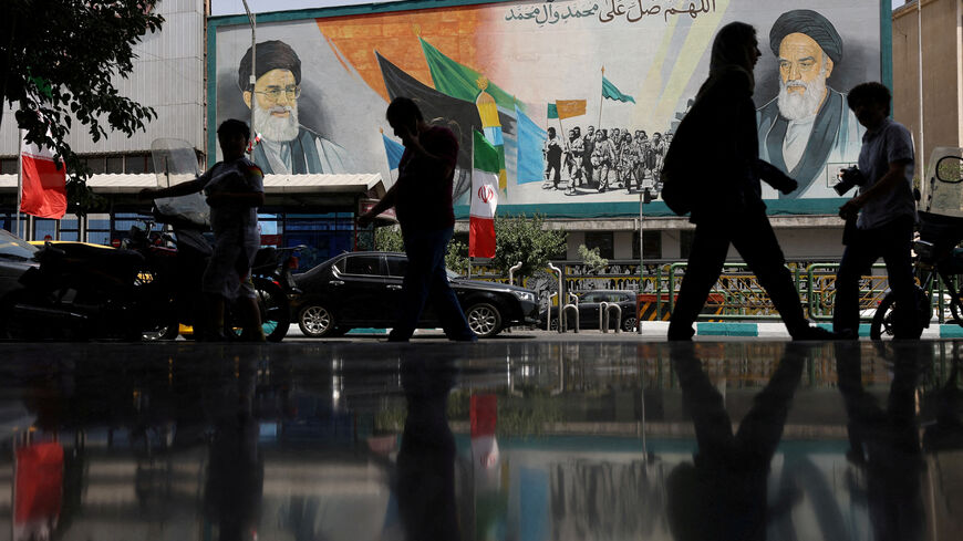 FILE PHOTO: People walk next to a mural with a picture of Iran's Supreme Leader, Ayatollah Ali Khamenei, on a street, early hours of ceasefire, in Tehran, Iran, June 24, 2025. Majid Asgaripour/WANA (West Asia News Agency) via REUTERS/File Photo