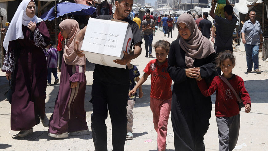 FILE PHOTO: The son of displaced Palestinian woman Iman Suleiman, from Beit Lahiya, carries a box of aid the family received, distributed by the Emirates Red Crescent, in Gaza City, June 26, 2025. REUTERS/Khamis Al-Rifi/File Photo