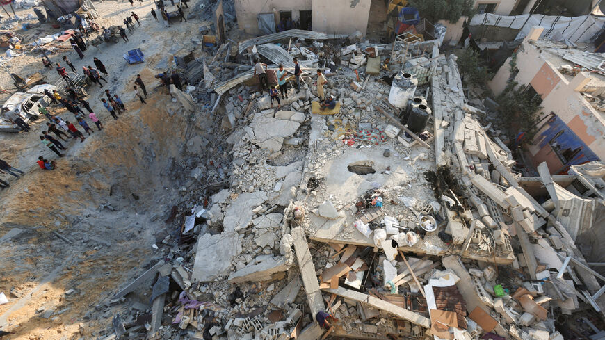 FILE PHOTO: Palestinians gather at the site of an overnight Israeli air strike on a house, in Khan Younis in the southern Gaza Strip, July 28, 2025. REUTERS/Ramadan Abed/File Photo