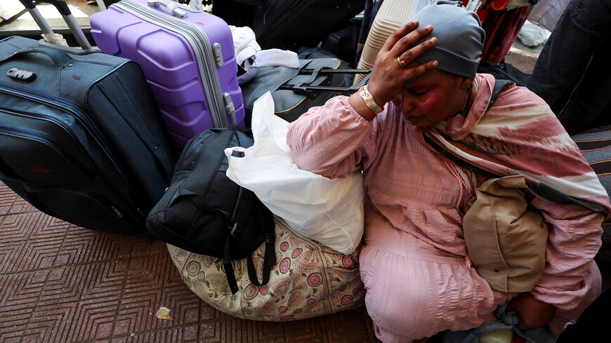 A Sudanese mother reacts next to her luggage as families displaced by conflict between the Sudanese Armed Forces and the Rapid Support Forces (RSF) crowd at Cairo's main station to board a free train with a voluntary return coordinated by the Egyptian government to Aswan, where buses will take them back to their homes in Khartoum, in Cairo Egypt, July 28, 2025. REUTERS/Amr Abdallah Dalsh