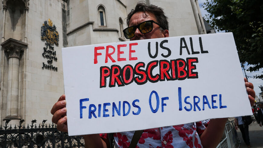 A demonstrator holds a placard, outside London's High Court as judges decide whether the co-founder of Palestine Action can challenge the UK government's ban on the group, in London, Britain, July 30, 2025. REUTERS/Toby Melville