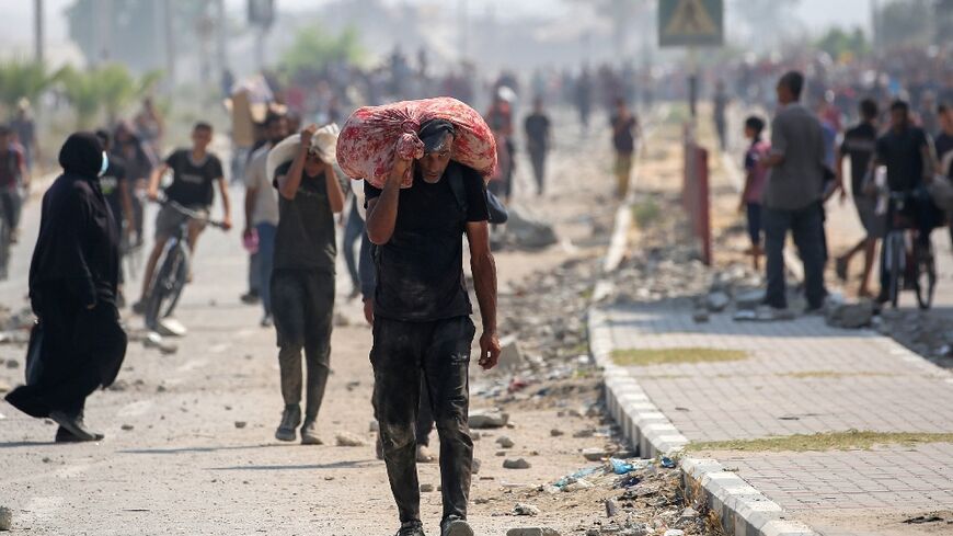 Palestinians return to Gaza's Nuseirat refugee camp with food parcels they have managed to obtain from an aid distribution point in the Israeli-controlled Netzarim Corridor.