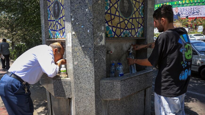 Tehran residents drink from a public fountain as temperatures in the Iranian capital soar.