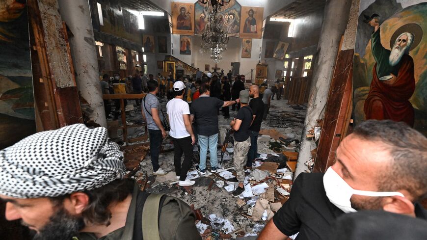 People and rescuers inspect the damage at the site of a reported suicide attack at the Saint Elias church in Damascus on June 22, 2025. 