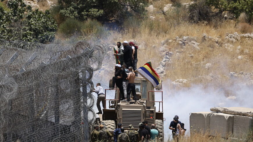 Israeli troops use tear gas to disperse the crowds as Druze Syrians attempt to cross the dividing line from Syria into the Israeli-annexed Golan Heights on July 16, 2025.