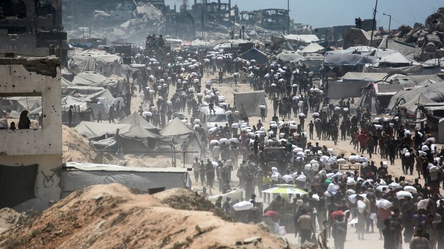 Palestinians carry bags of flour from aid trucks in the northern Gaza Strip
