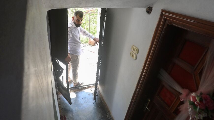 A man opens the door to a house, the site of a reported operation by the US-led anti-jihadist coalition, in the town of Atme in northwestern Syria