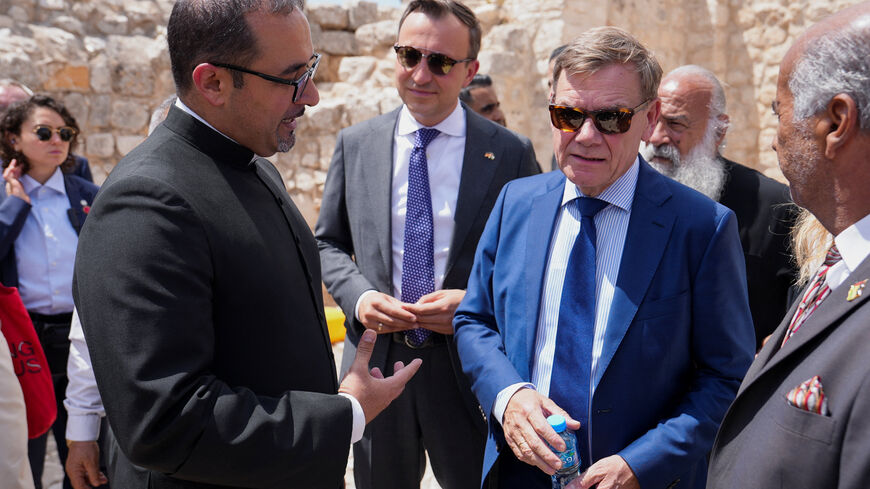 Germany's Foreign Minister Johann Wadephul listens a member of clergy during the visit to the town of Taybeh, a Christian village in the Israeli-occupied West Bank, following settler attacks, August 1, 2025. REUTERS/Ali Sawafta