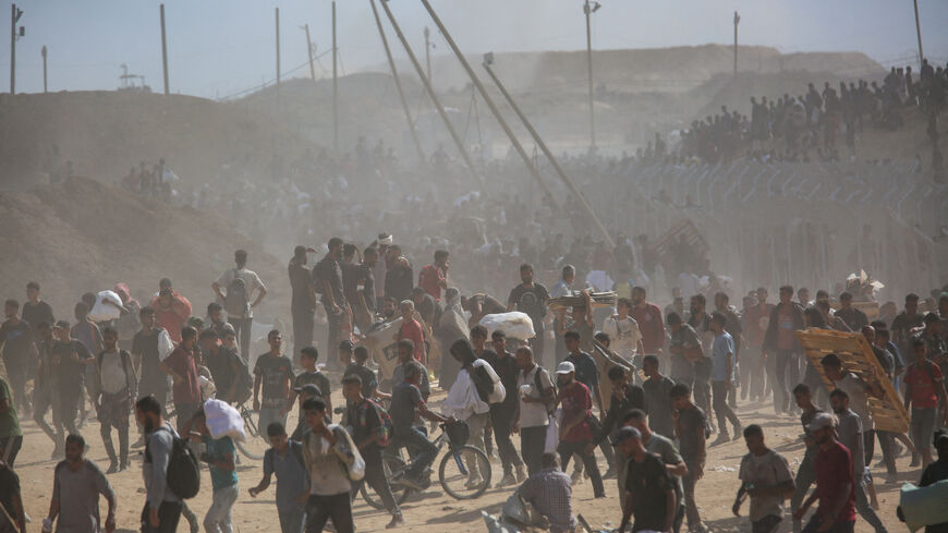 FILE PHOTO: Palestinians carry aid supplies which they received from the U.S.-backed Gaza Humanitarian Foundation, in the central Gaza Strip, July 31, 2025. REUTERS/Stringer/File Photo