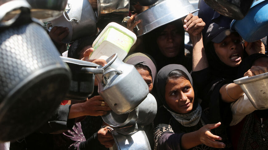 FILE PHOTO: Palestinians wait to receive food from a charity kitchen, amid a hunger crisis, in Khan Younis, southern Gaza Strip, August 4, 2025. REUTERS/Hatem Khaled/File Photo