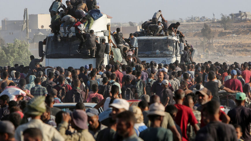 FILE PHOTO: Palestinians climb onto trucks as they seek aid supplies in Khan Younis, southern Gaza Strip, August 4, 2025. REUTERS/Hatem Khaled/File Photo